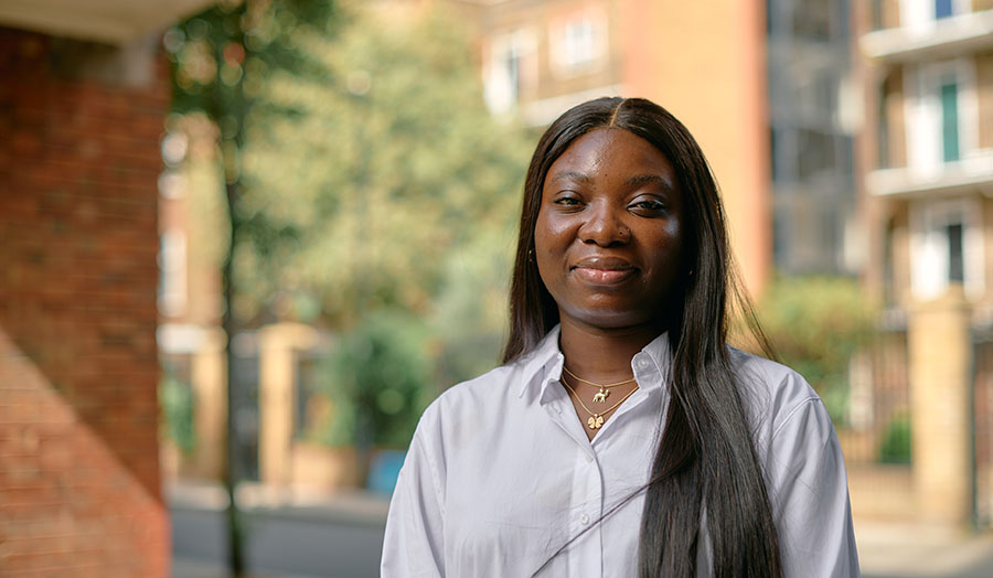 Dr Mariam Akinlolu standing by trees and a building