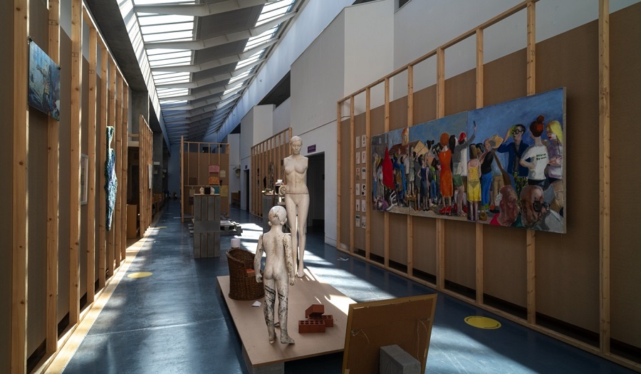 paintings and sculptures in a gallery with a glass roof