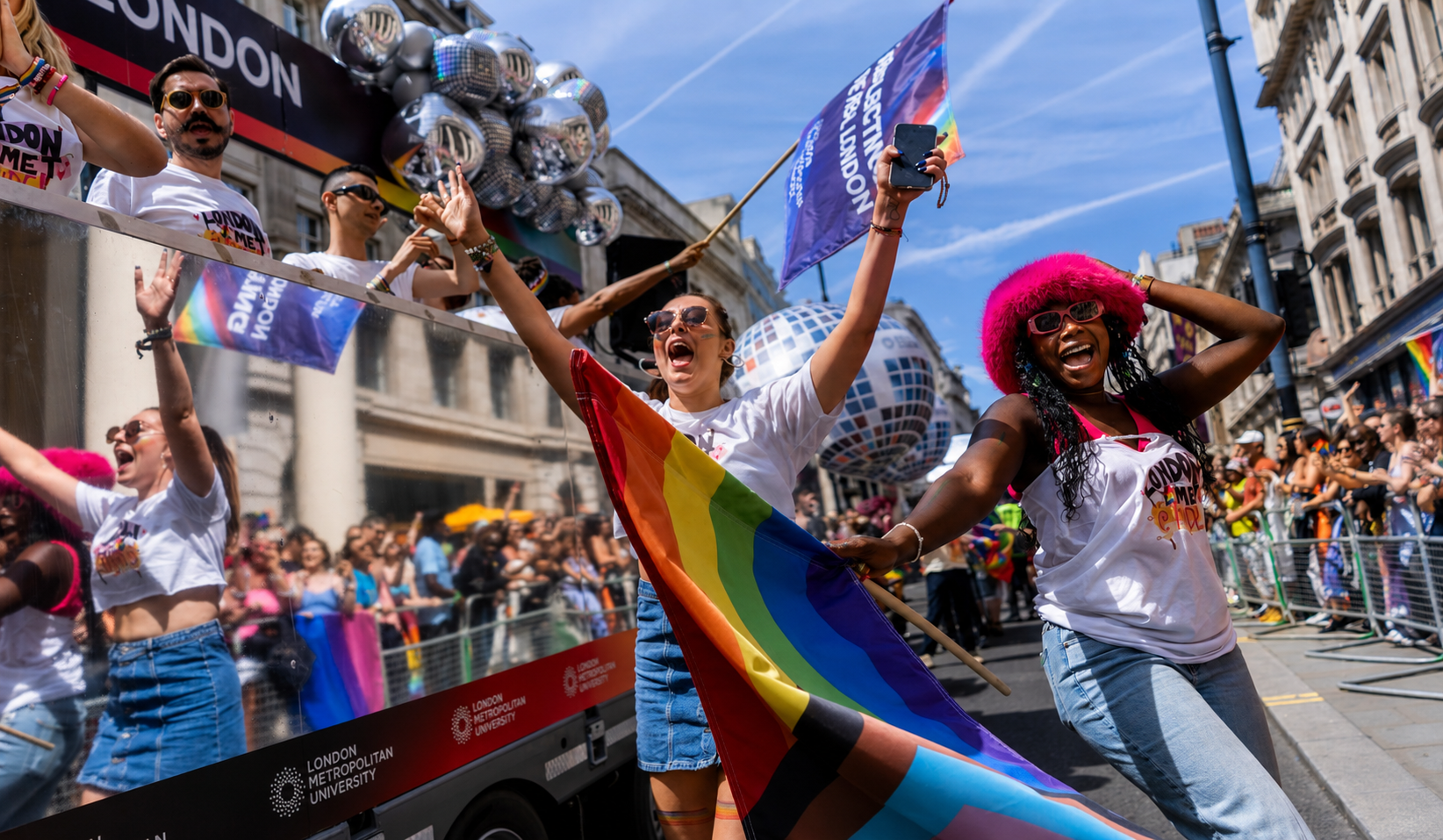 People celebrating at London's Pride parade alongside a London Metropolitan University float