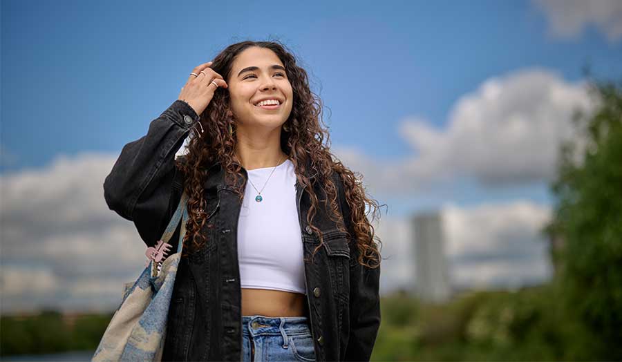 Carola smiling, brushing her hair back