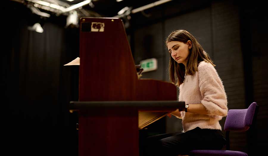 Stefani playing the piano on campus