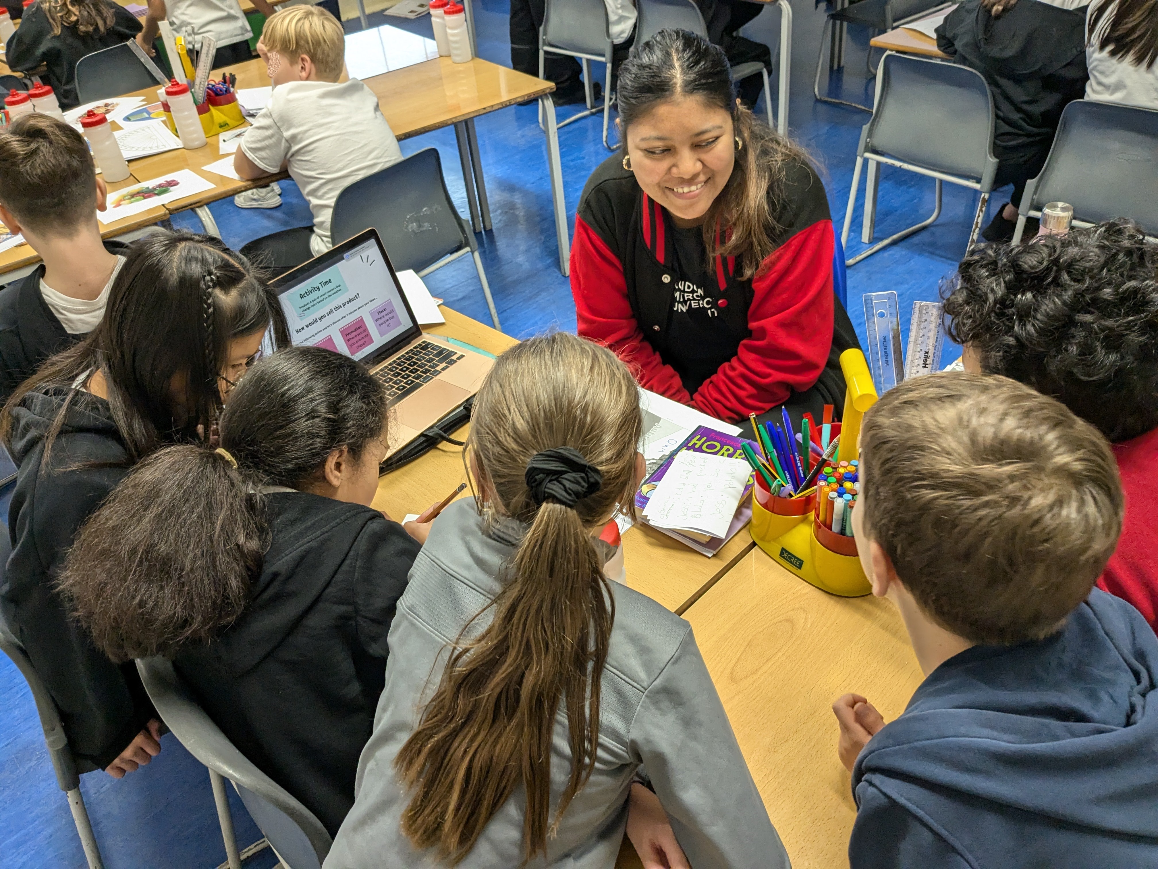 A student ambassadors deliveres a workshop with a table of students