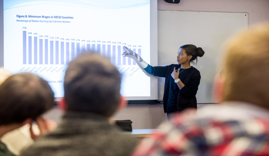 A female academic of colour presenting to a class