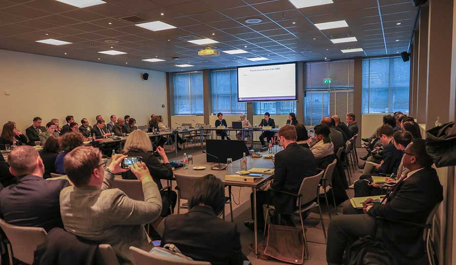 A room full of people listening to a presentation at the OPCW side event.