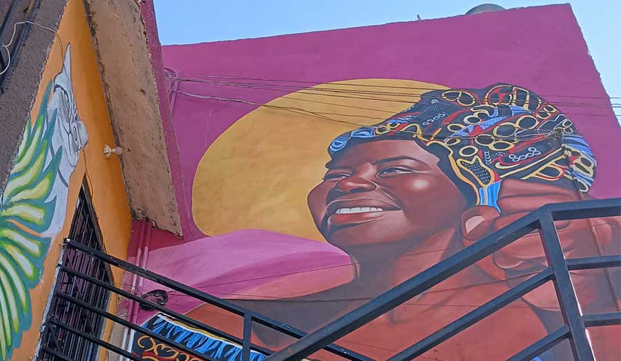A brightly coloured mural of a woman smiling