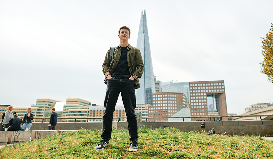 Person standing on grass in front of The Shard in London