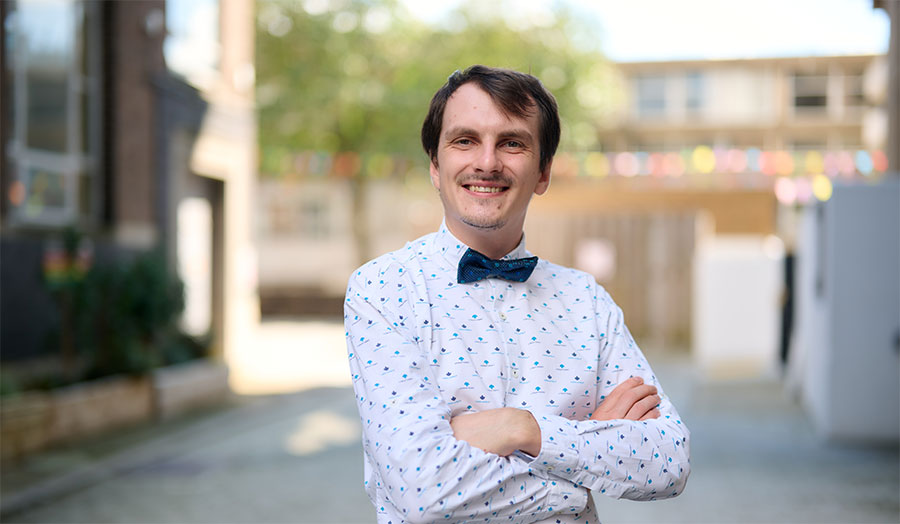 Michael Novosolev wearing a bow tie and shirt pictured smiling on campus