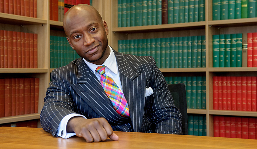 Tunde Okewale, black male alumni in a suit